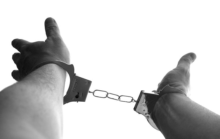 Crime suspect's hands locked in handcuffs